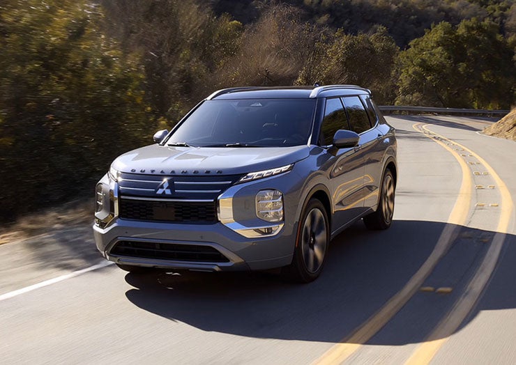 Front shot of the 2026 Outlander PHEV on a scenic road